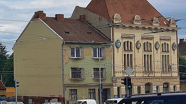 Husovická sokolovna (vpravo) ještě se sousedním domem. Po jeho zbourání se na boční stěně sokolovny odkryla reklamní plocha.