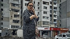 Ukrajinka prochází mezi troskami obytné budovy po noním ostelování v...