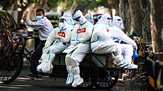 Zdravotníci v ochranných oblecích na nákladním kole v �anghaji (15. �ervna 2022)