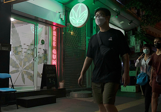 Chodci v Bangkoku míjejí nově otevřený obchod s marihuanou. (10. srpna 2022)