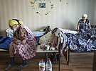 Jednasedmdesátiletá Vera Vasiuková (vlevo) sedí na posteli v centru pro...