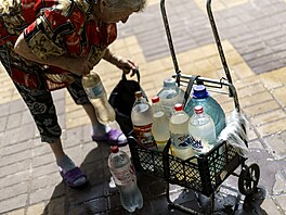 76letá Ljuba Mahlijová balí bednu s lahvemi s vodou, které si naplnila ve...