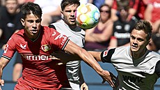 Záloník Leverkusenu Adam Hloek v souboji s hráem Augsburgu Robertem Gumnym...