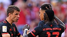 Hráči Bayernu Mnichov Thomas Müller a Sadio Mané slaví gól Jamala Musialy v...