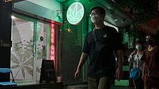 Chodci v Bangkoku míjejí nově otevřený obchod s marihuanou. (10. srpna 2022)