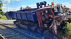 Nákladní automobil se zničenou kabinou po srážce s osobním vlakem ve...