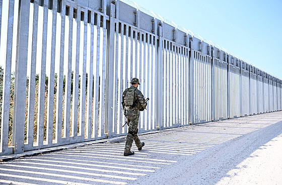 Voják hlídkuje u ocelového plotu postaveného podél eky Evros v oblasti Feres...