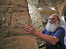 Archeolog Ji�� Kls�k ukazuje bos� na jednom z kamen� zdiva v interi�ru hradu...