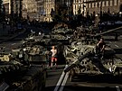 Lidé chodí kolem zniených ruských vojenských vozidel vystavených v centru...