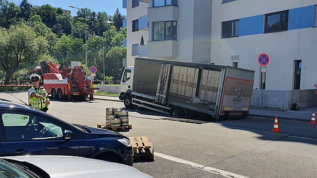 Nkladn vz naloen npoji se bhem jzdy propadl do silnice v brnnsk ulici Po. Hasii nklad vyskldali, aby auto odlehili.