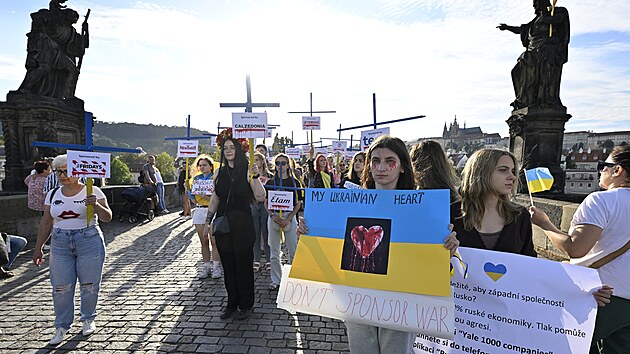 Asi �edes�t lid� se se�lo v ned�ln� podve�er na Karlov� most�, aby protestem s n�zvem K��ov� cesta sponzor� rusk� ekonomiky upozornilo na firmy, kter� i p�es ruskou okupaci Ukrajiny st�le z�st�vaj� na rusk�m trhu. (21. srpna 2022)