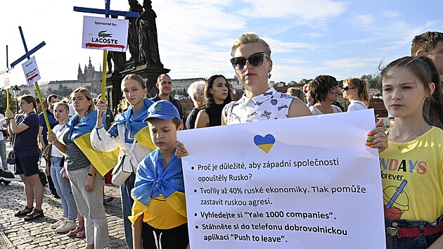 Asi �edes�t lid� se se�lo v ned�ln� podve�er na Karlov� most�, aby protestem s n�zvem K��ov� cesta sponzor� rusk� ekonomiky upozornilo na firmy, kter� i p�es ruskou okupaci Ukrajiny st�le z�st�vaj� na rusk�m trhu. (21. srpna 2022)