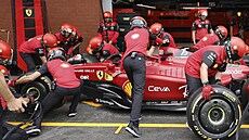 Carlos Sainz z Ferrari v péi mechanik pi prvním tréninku na Velkou cenu...