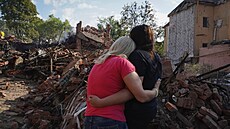 Ukrajinky se objímají před budovou zničenou během raketového útoku v Charkově... | na serveru Lidovky.cz | aktuální zprávy