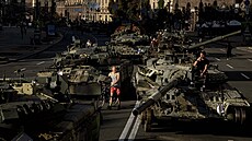 Lidé chodí kolem zničených ruských vojenských vozidel vystavených v centru...