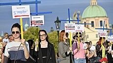 Asi �edesát lidí se se�lo v ned�lní podve�er na Karlov� most�, aby protestem s názvem K�í�ová cesta sponzor� ruské ekonomiky upozornilo na firmy, které i p�es ruskou okupaci Ukrajiny stále z�stávají na ruském trhu. (21. srpna 2022)