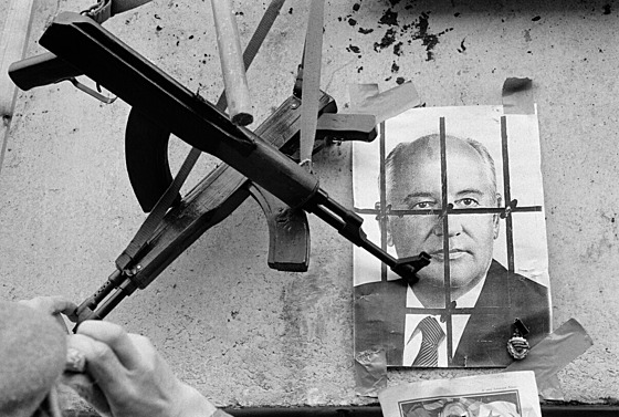 Zbra� visí p�ed fotkou posledního sov�tského lídra Michaila Gorba�ova, který...