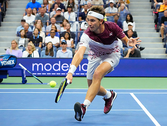 Casper Ruud z Norska se natahuje po balonku ve tvrtfinále US Open.