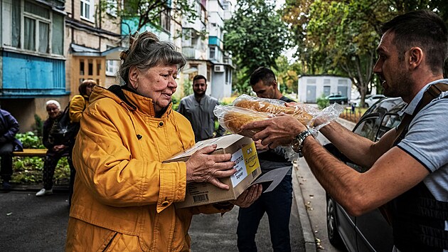 Lidé čekají na jídlo rozdávané dobrovolníky v charkovské čtvrti Saltivka, jedné z nejvíce poškozených obytných oblastí. (6. září 2022)