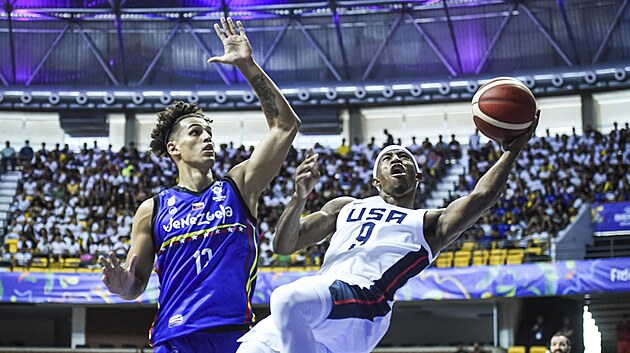 Americk basketbalista Craig Sword pad v zpase s Venezuelou, brn ho Edgar Martinez.