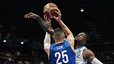 Alex Len z Ukrajiny p�ihrává kolem �eckého pivota Thanasise Adetokunba.