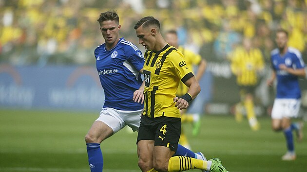 Nico Schlotterbeck z Borussie Dortmund (vpedu) vede m bhem zpasu proti Schalke 04.