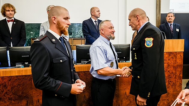 Šéf městské policie Miroslav Plaček blahopřeje strážníkovi Tomáši Janáčkovi.
