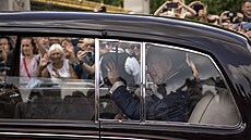 Král Charles III. přijíždí do Buckinghamského paláce a zdraví přihlížející....