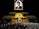 Portrét bývalého premiéra Japonska inzó Abeho visí nad pódiem jeho státního...