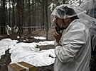 Ukrajinský záchraná odpoívá bhem exhumaních pracích na masovém hrobu v...