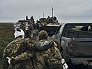 Ukrajinský voják pomáhá zrannému kamarádovi na osvobozeném území v Charkovské...