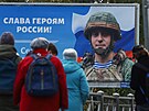 Obyvatelé Petrohradu stojí ped plakátem vojáka s nápisem "Sláva ruským...