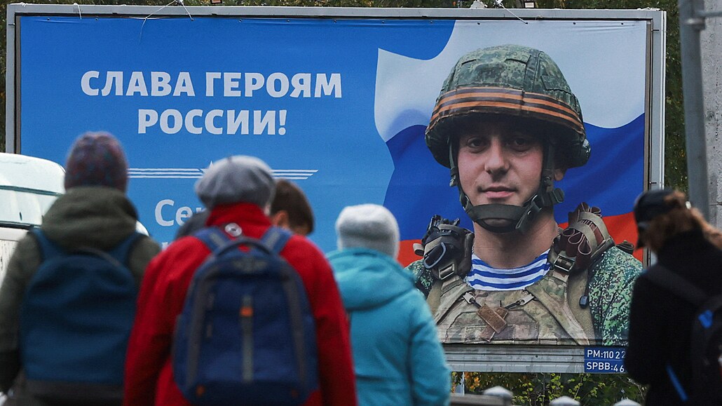 Obyvatelé Petrohradu stojí před plakátem vojáka s nápisem "Sláva ruským...