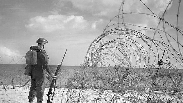 Britský voják hlídkující na pláži