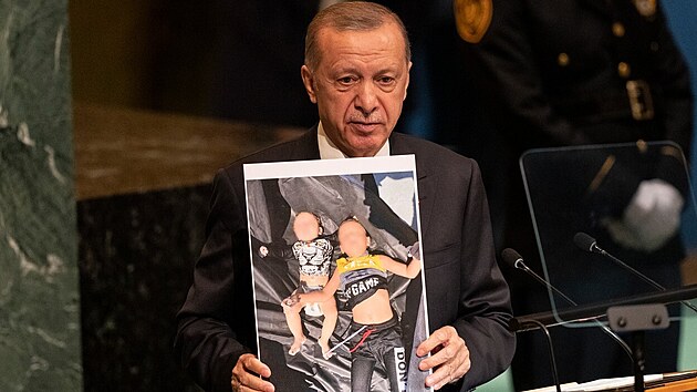 Tureck prezident Recep Tayyip Erdogan s fotografi syrskch migrant, kte utonuli na cest do Evropy. (20. z 2022)