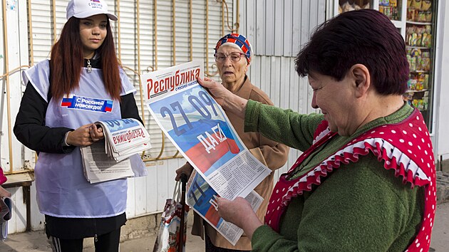 Dobrovolníci samozvané Luhanské lidové republiky roznáší místním občanům noviny s informacemi k referendu o připojení tohoto separatistického útvaru k Rusku. (22. září 2022)