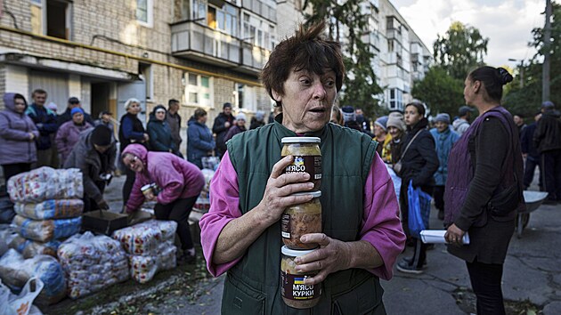 Obyvatelka msta Izjum si odn potraviny z distribunho msta humanitrn pomoci. (25. z 2022)