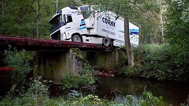 Řidič kamionu si na Tachovsku krátil cestu přes les, zůstal viset na dřevěném mostě. (26. 9. 2022)
