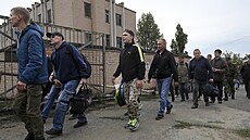 Ru�tí rekruti procházejí kolem vojenského náborového st�ediska v ruském...