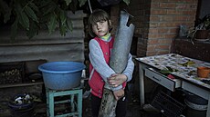 Sedmiletá Veronika Tkačenková drží kus rakety Grad, která zasáhla dům její...