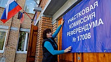 lenka volební komise vyvuje transparent na dvee volební místnosti ped...