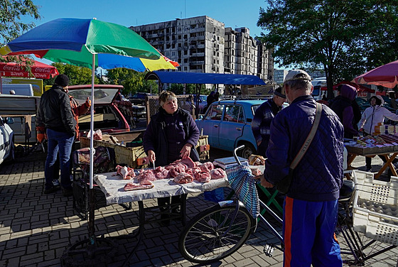 Muž nakupuje maso u stánku na ulici okupovaného Mariupolu. (25. září 2022)
