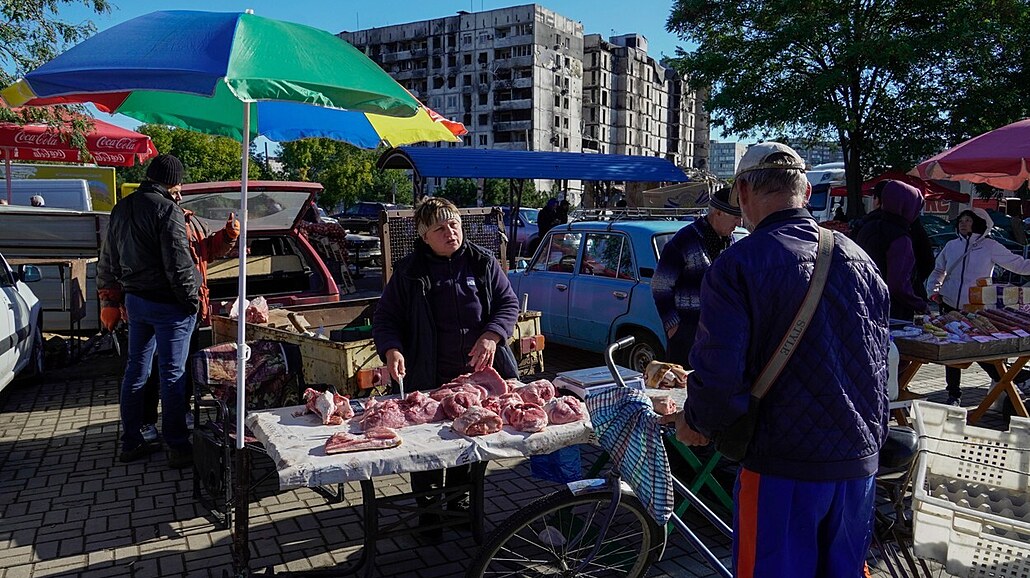 Mu nakupuje maso u stánku na ulici okupovaného Mariupolu. (25. záí 2022)