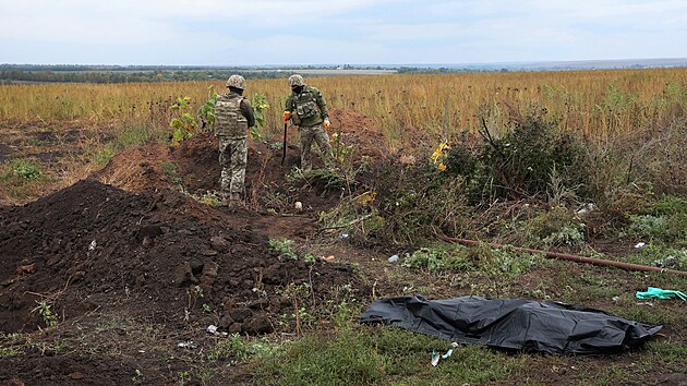 lenov armdnho tvaru zabvajcho se ptrnm po padlch vojcch vyzvedvaj v Charkovsk oblasti tlo ukrajinskho vojka. (16. z 2022)