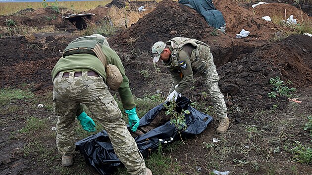 lenov armdnho tvaru zabvajcho se ptrnm po padlch vojcch vyzvedvaj v Charkovsk oblasti tlo ukrajinskho vojka. (16. z 2022)