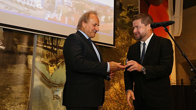 Guvernér České národní banky Aleš Michl (vpravo) předává minci do rukou starosty Litoměřic Ladislava Chlupáče.
