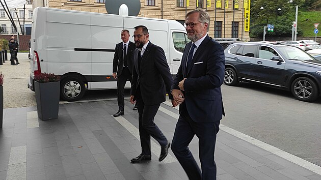Premiér Petr Fiala přichází v dobré náladě do volebního štábu koalice SPOLU v hotelu v centru Prahy