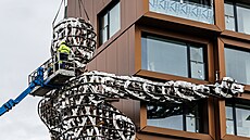 V Karlíně podepírá novostavbu obří socha ženy. (2. října 2022)