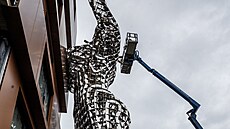 V Karlín podpírá novostavbu obí socha eny. (2. íjna 2022)