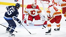Dan Vlada (80) z Calgary Flames zasahuje proti Winnipeg Jets, zakonil Mark...